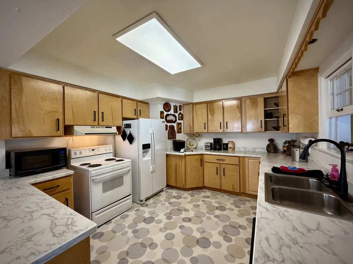 A warm, inviting kitchen with classic cabinets, modern appliances, decorative wall plates, and ample counter space. The room feels ready for meal preparation and family gatherings, emphasizing the home's capacity for creating shared culinary experiences.